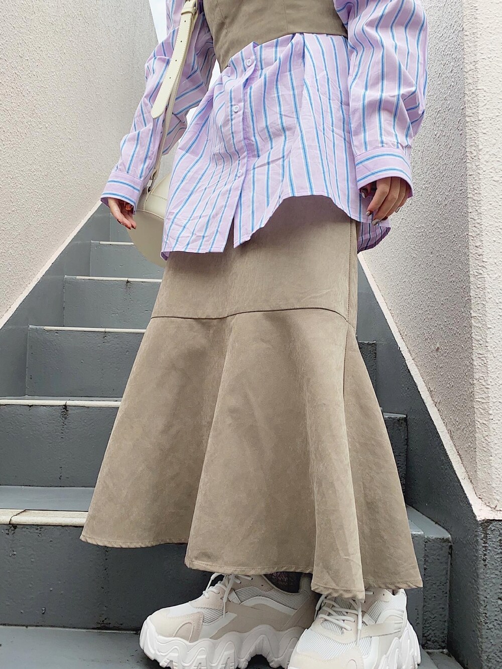 ベージュ系のワンピース、ホワイト系のバッグ、ホワイト系のスニーカーを着用したレディースの秋コーディネートの2枚目の写真