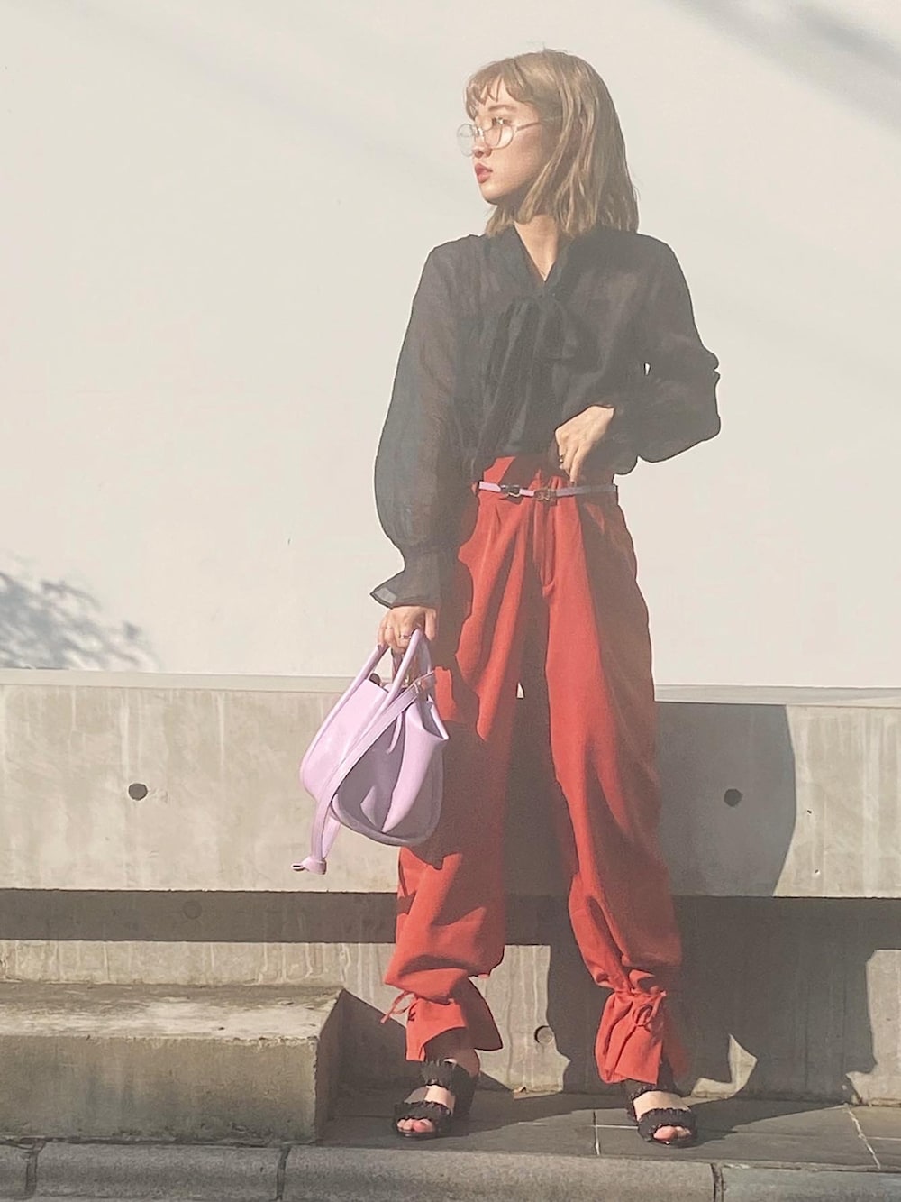 ブルー系のシャツ/ブラウス、オレンジ系のパンツ、パープル系のバッグを着用したレディースの夏コーディネートの2枚目の写真