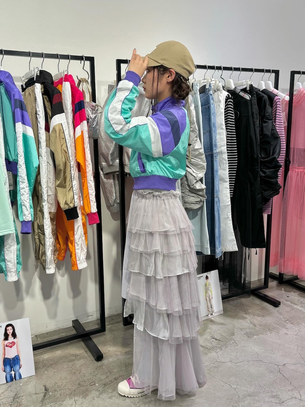 ピンク系のスニーカー、ブルー系のデニムパンツ、パープル系のナイロンジャケットを着用したレディースの春コーディネートの2枚目の写真