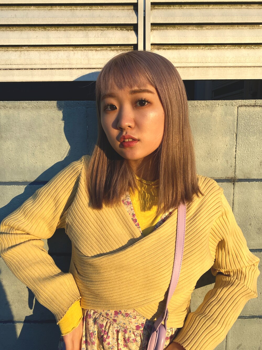 ホワイト系のワンピース/ドレス、イエロー系のニット/セーター、パープル系のバッグを着用したレディースの冬コーディネートの2枚目の写真