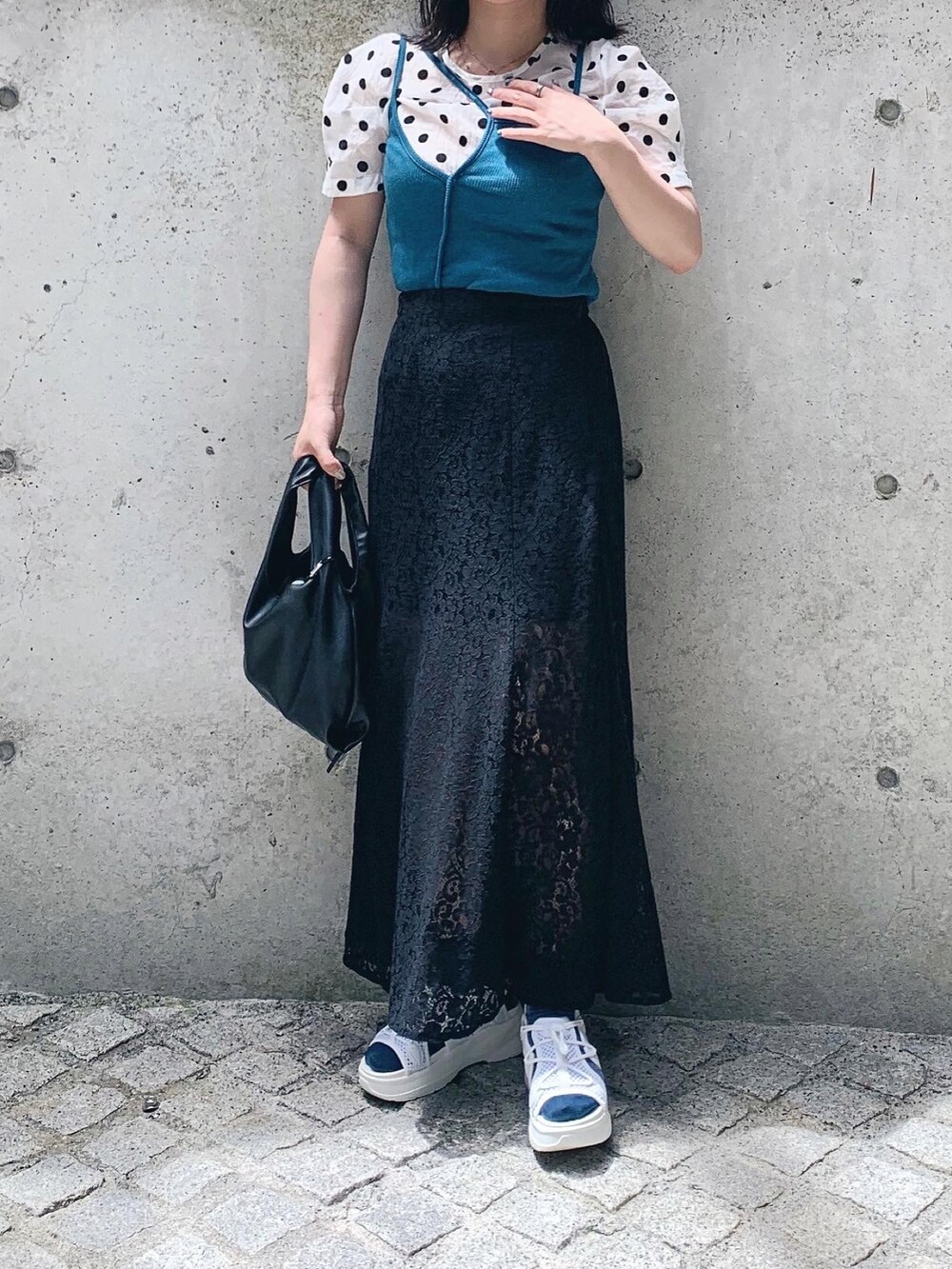 ブラック系のスカート、ブルー系のキャミソール、ホワイト系のトップスを着用したレディースの秋コーディネートの2枚目の写真