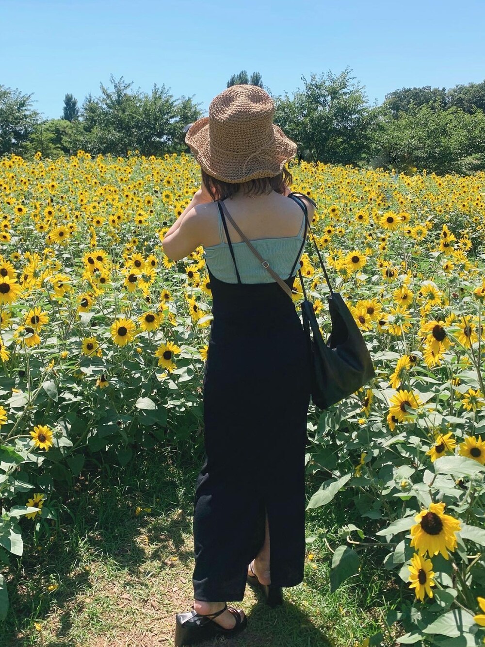 ブラック系のサンダル、ブラック系のワンピース、ベージュ系のハットを着用したレディースの秋コーディネートの3枚目の写真