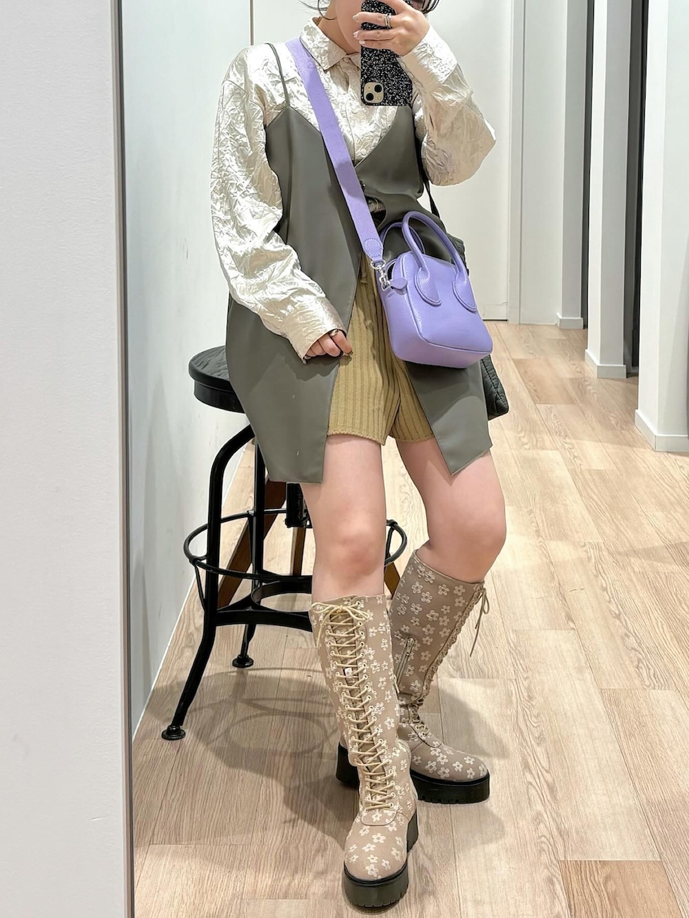 パープル系のハンドバッグ、ベージュ系のブーツ、ホワイト系のシャツ/ブラウスを着用したレディースの冬コーディネートの2枚目の写真