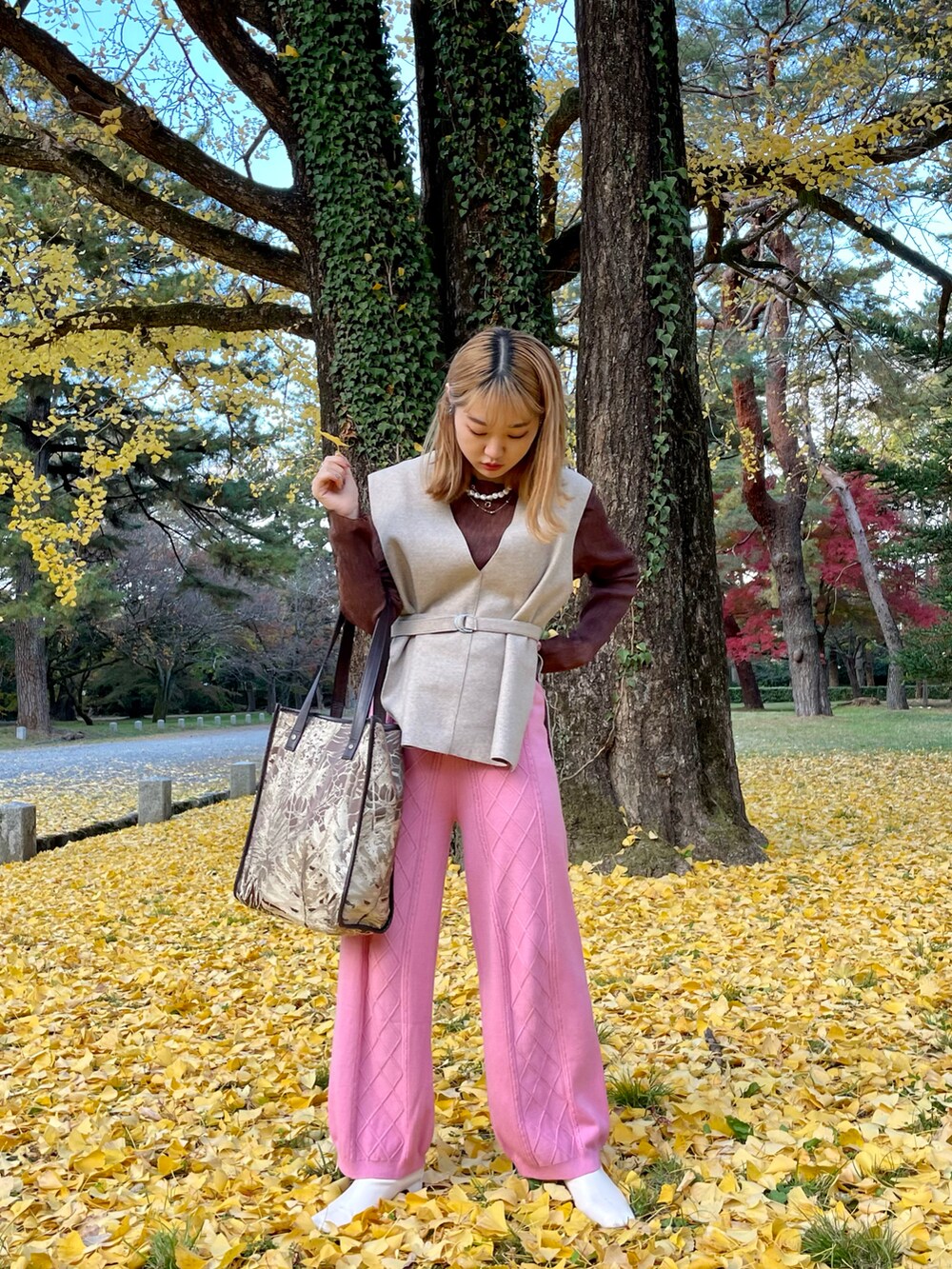 ホワイト系のブーツ、ピンク系のパンツ、ブラウン系のトートバッグを着用したレディースの秋コーディネートの2枚目の写真