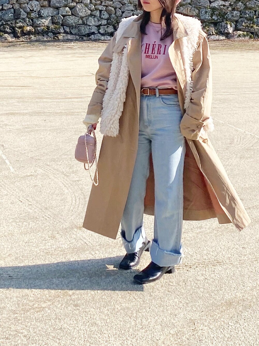 ブルー系のデニムパンツ、ピンク系のバッグ、ピンク系のスウェットを着用したレディースの春コーディネートの2枚目の写真