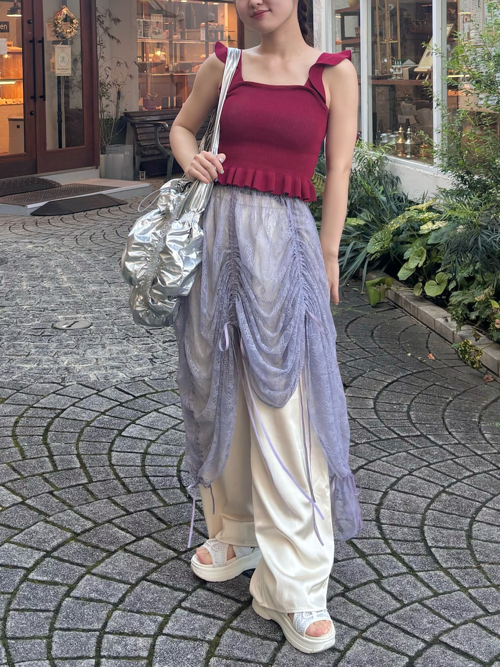 レッド系のトップス、パープル系のスカート、ホワイト系のサンダルを着用したレディースの秋コーディネートの2枚目の写真