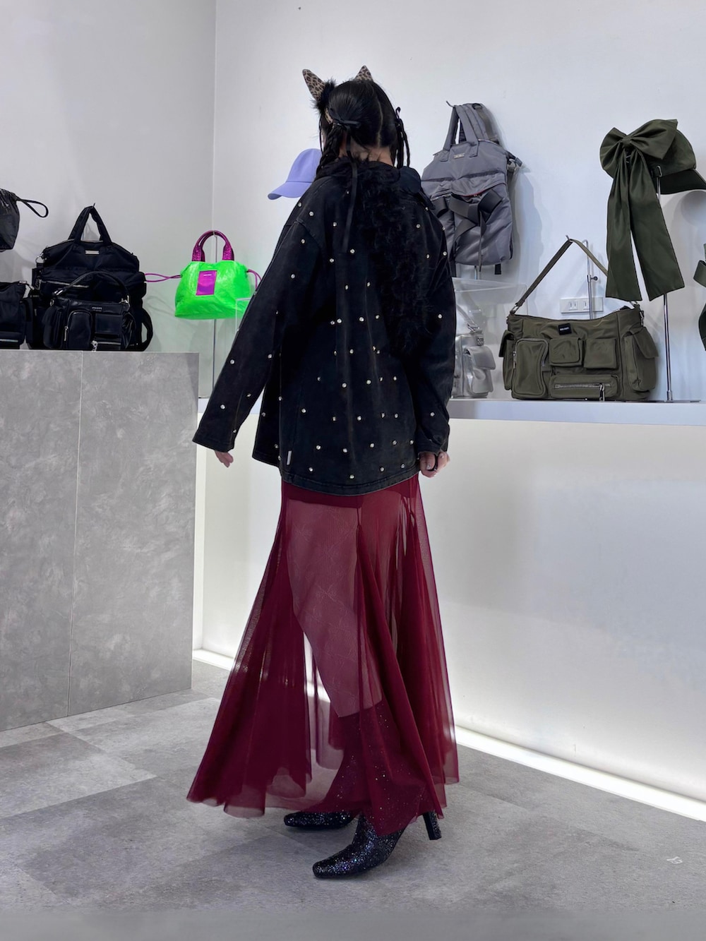 レッド系のスカート、ブラック系のTシャツ/カットソー、ブラック系のショルダーバッグを着用したレディースの秋コーディネートの3枚目の写真