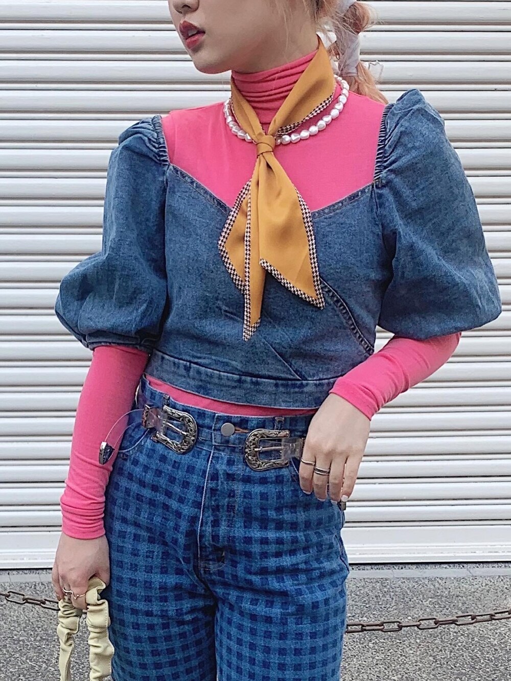 イエロー系のトレンチコート、ブルー系のデニムパンツ、ベージュ系のブーツを着用したレディースの春コーディネートの5枚目の写真