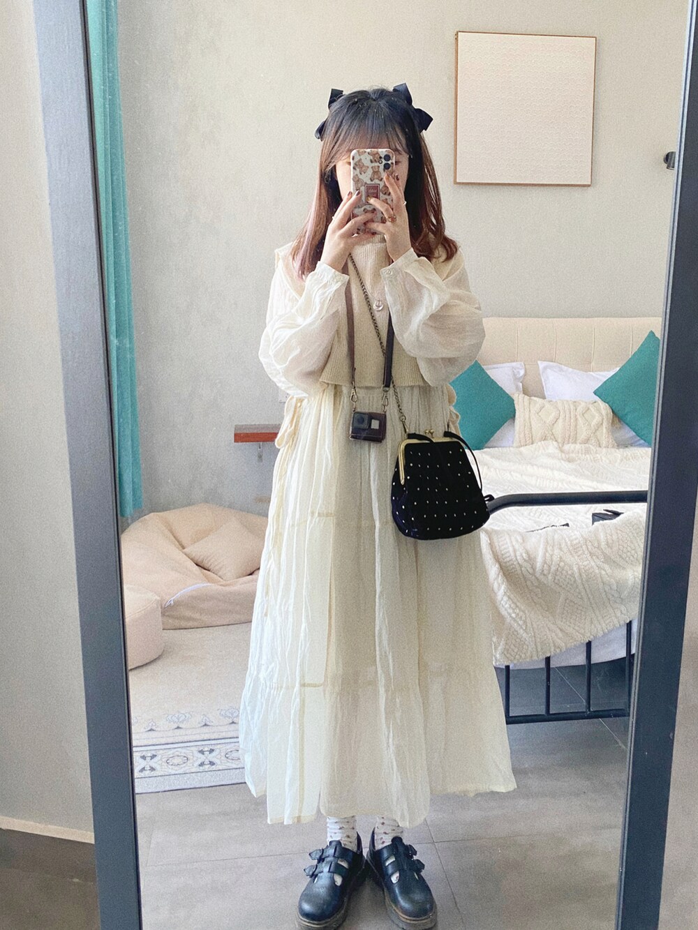 ブラック系のドレスシューズ、ホワイト系のワンピース、ホワイト系のベストを着用したレディースの冬コーディネートの2枚目の写真