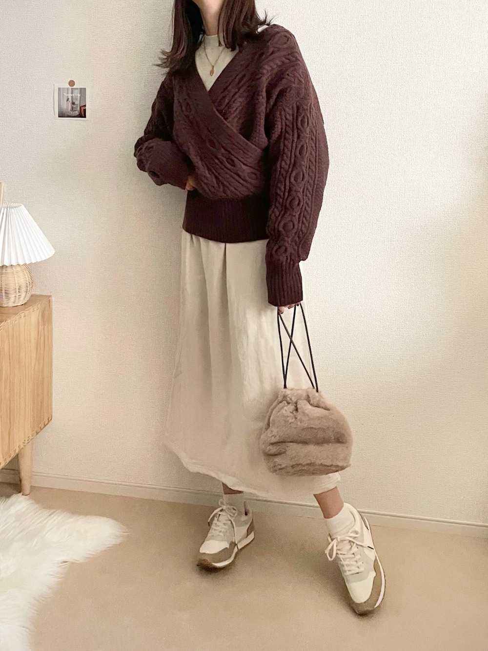 ブラック系のダウンジャケット/コート、ブラック系のスカート、ホワイト系のハンドバッグを着用したレディースの冬コーディネートの5枚目の写真