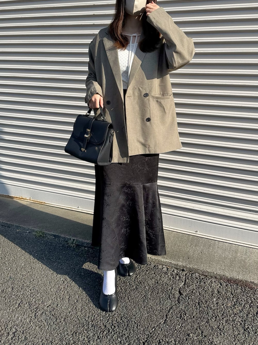 ベージュ系のテーラードジャケット、ホワイト系のTシャツ/カットソー、ホワイト系のスカートを着用したレディースの春コーディネートの3枚目の写真