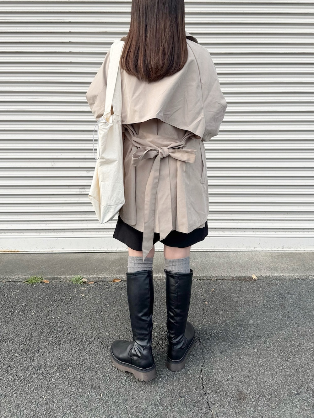 ベージュ系のトレンチコートを着用したレディースの春コーディネートの4枚目の写真