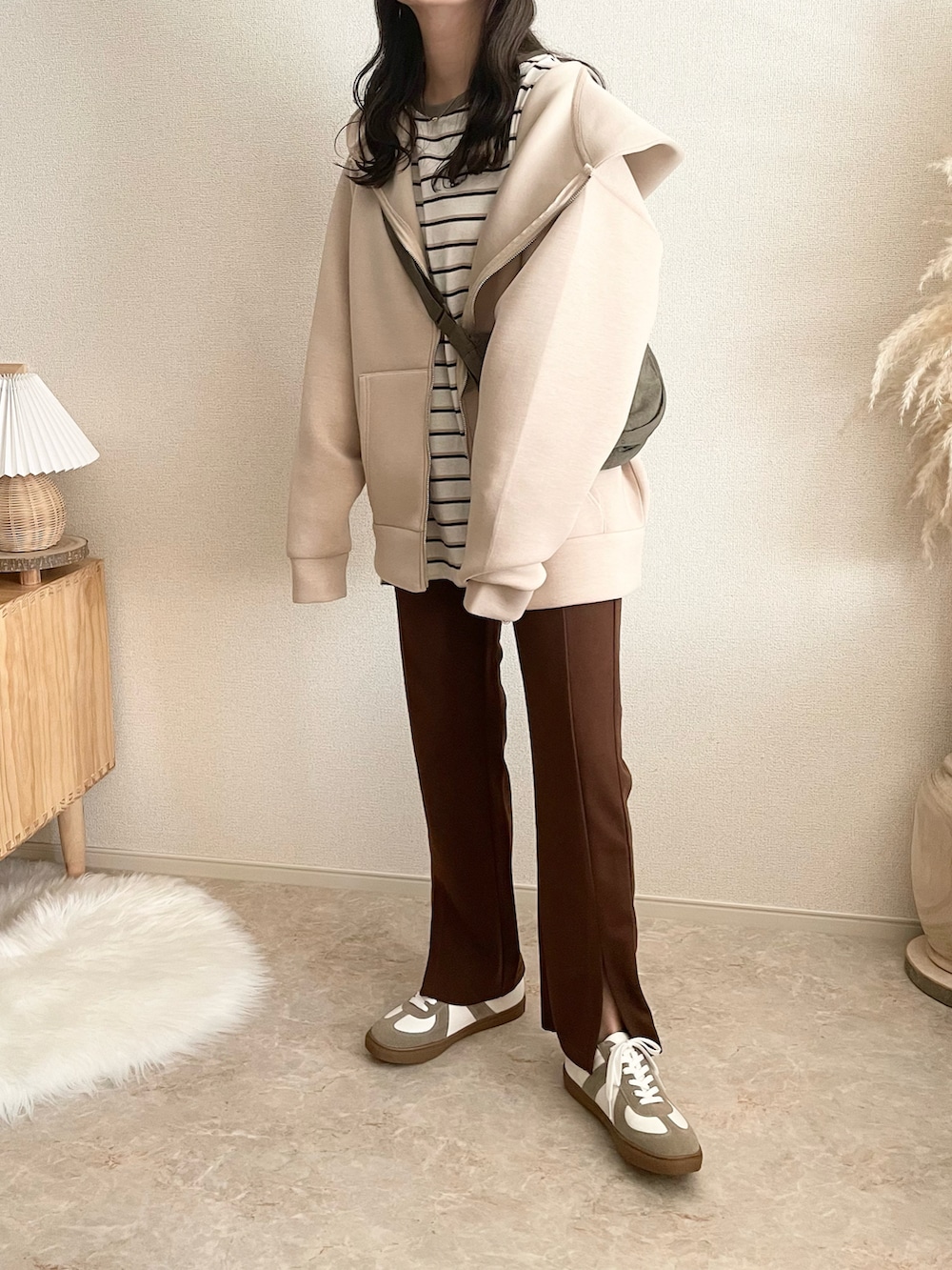 ベージュ系のパーカーを着用したレディースの秋コーディネートの2枚目の写真