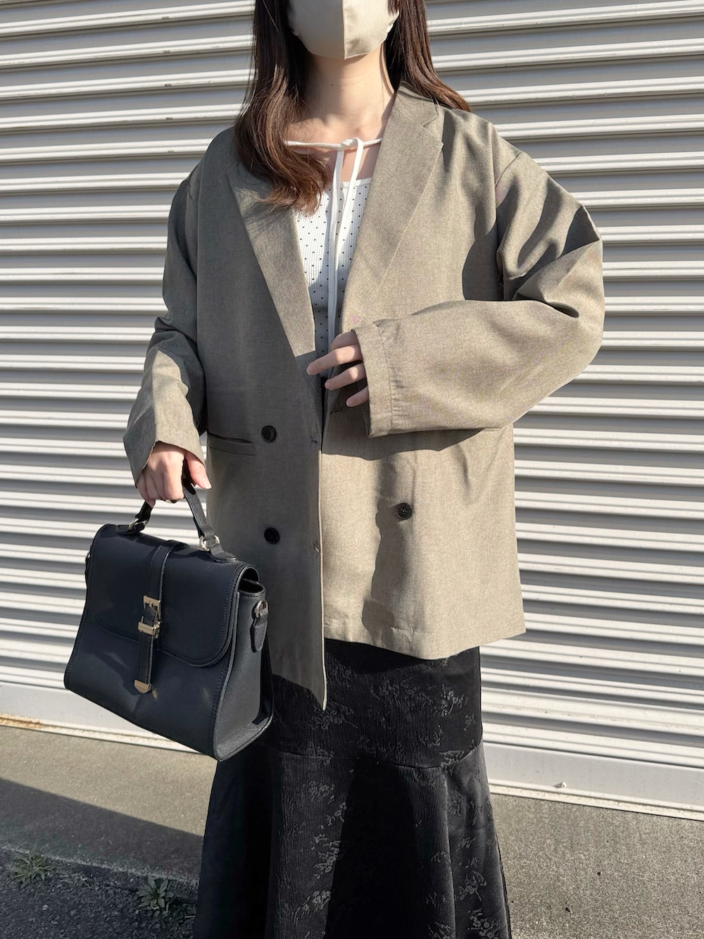 ベージュ系のテーラードジャケット、ホワイト系のTシャツ/カットソー、ホワイト系のスカートを着用したレディースの春コーディネートの2枚目の写真