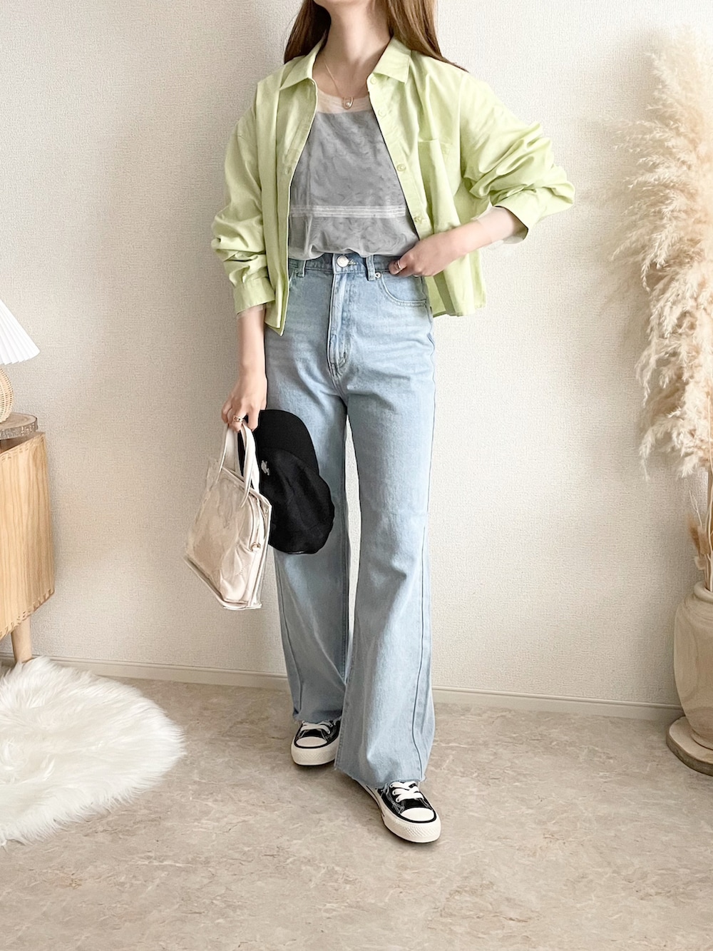 ブラック系のブルゾン、ホワイト系のトップス、ブルー系のデニムパンツを着用したレディースの春コーディネートの3枚目の写真