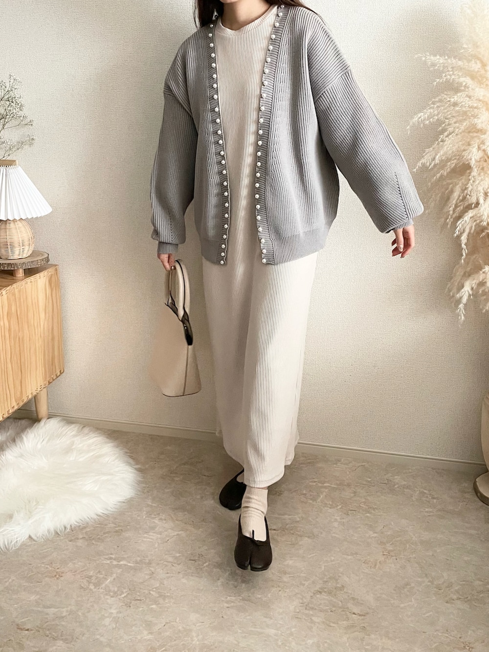 グレー系のカーディガン/ボレロ、ベージュ系のワンピース/ドレス、ブラウン系のバッグを着用したレディースの冬コーディネートの2枚目の写真