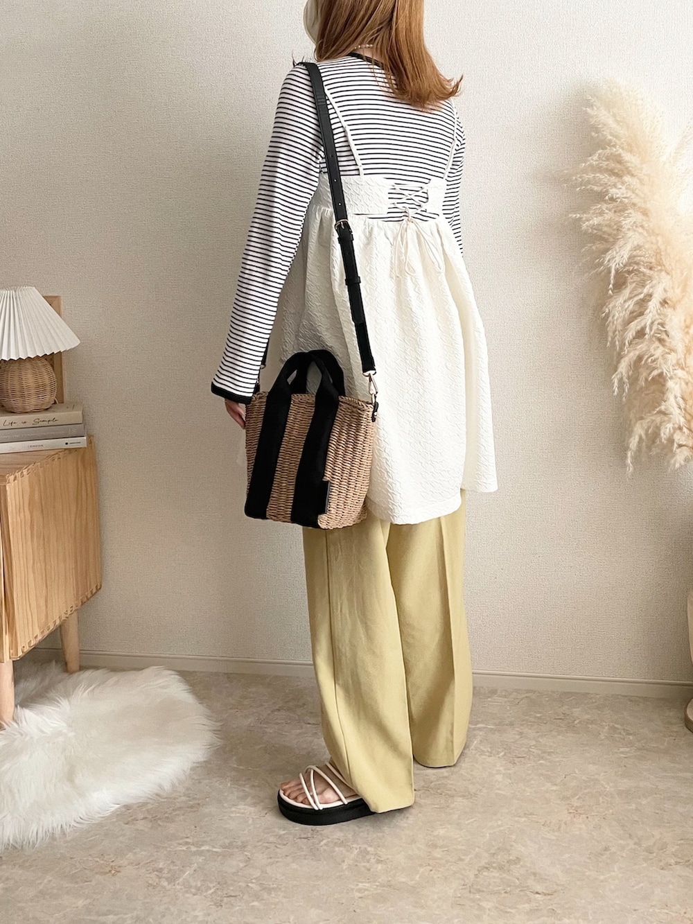 ホワイト系のワンピース、ブラック系のTシャツ/カットソー、ベージュ系のショルダーバッグを着用したレディースの春コーディネートの3枚目の写真