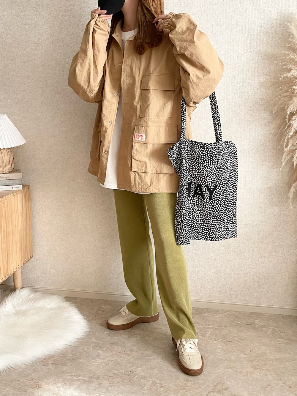 ベージュ系のマウンテンパーカー、ブラック系のショルダーバッグを着用したレディースの春コーディネートの3枚目の写真