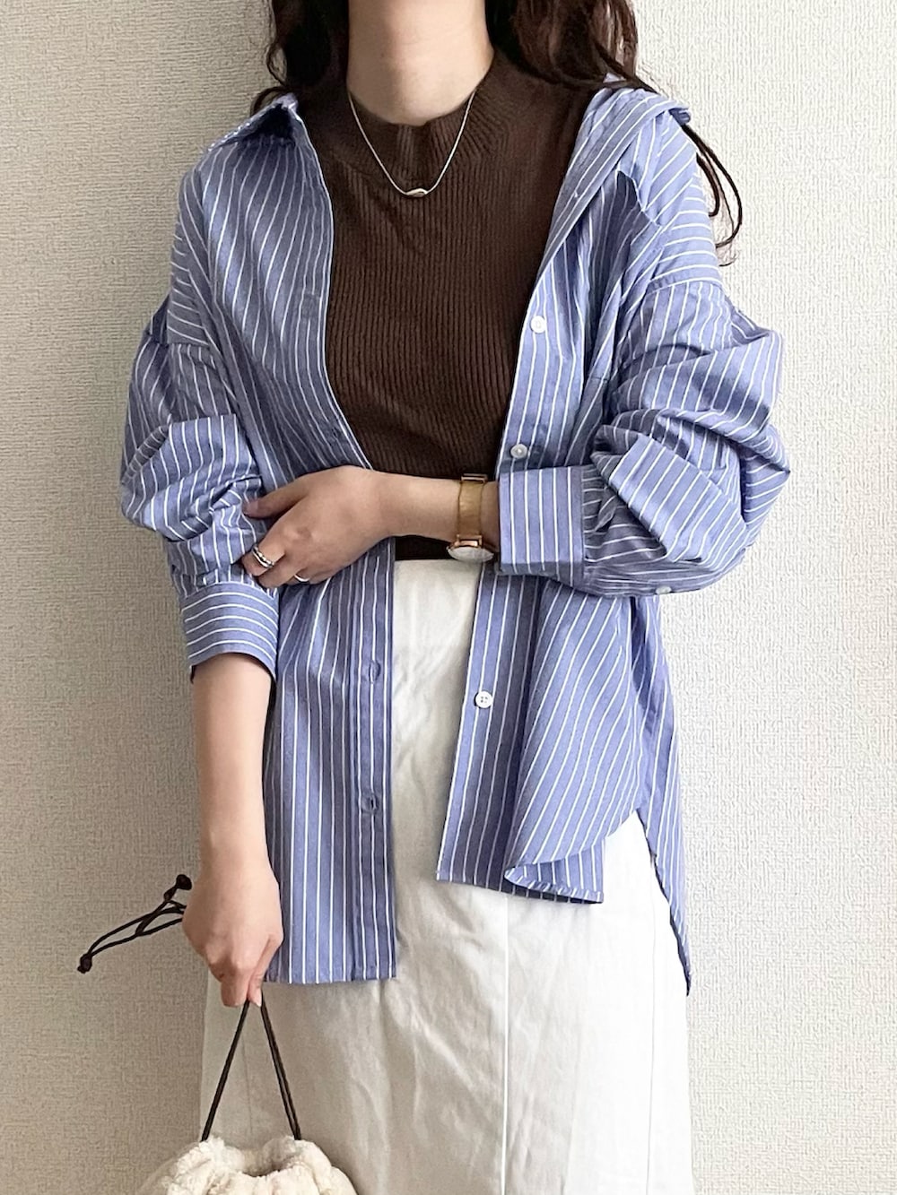 ブラウン系のニット/セーター、ブルー系のシャツ/ブラウスを着用したレディースの夏コーディネートの3枚目の写真