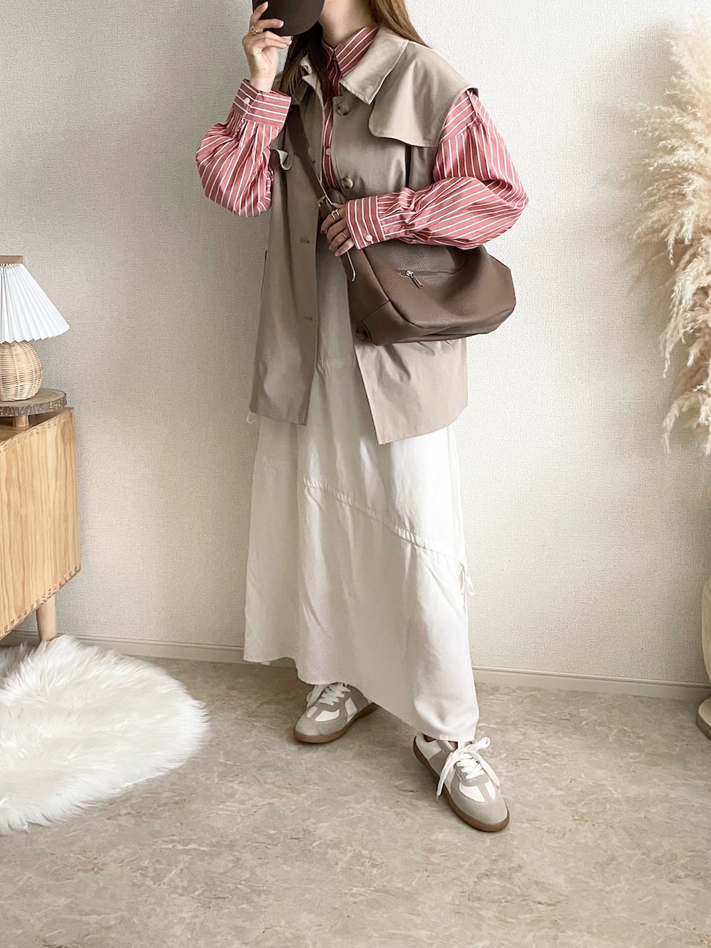 オレンジ系のシャツ/ブラウス、ホワイト系のTシャツ/カットソー、グレー系のデニムスカートを着用したレディースの春コーディネートの2枚目の写真