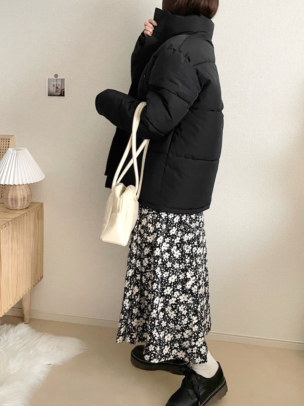 ブラック系のダウンジャケット/コート、ブラック系のスカート、ホワイト系のハンドバッグを着用したレディースの冬コーディネートの2枚目の写真