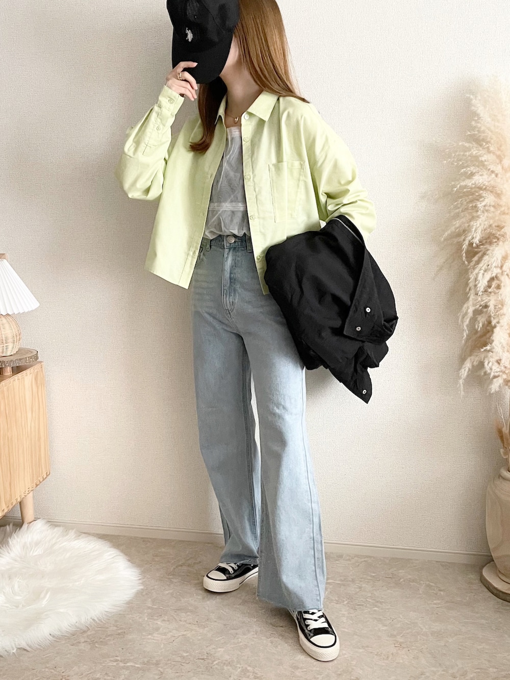 ブラック系のブルゾン、ホワイト系のトップス、ブルー系のデニムパンツを着用したレディースの春コーディネートの2枚目の写真