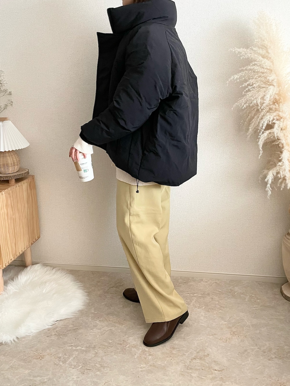 ブラック系のダウンジャケット/コート、イエロー系のその他パンツ、ブラウン系のローファーを着用したレディースの冬コーディネートの3枚目の写真