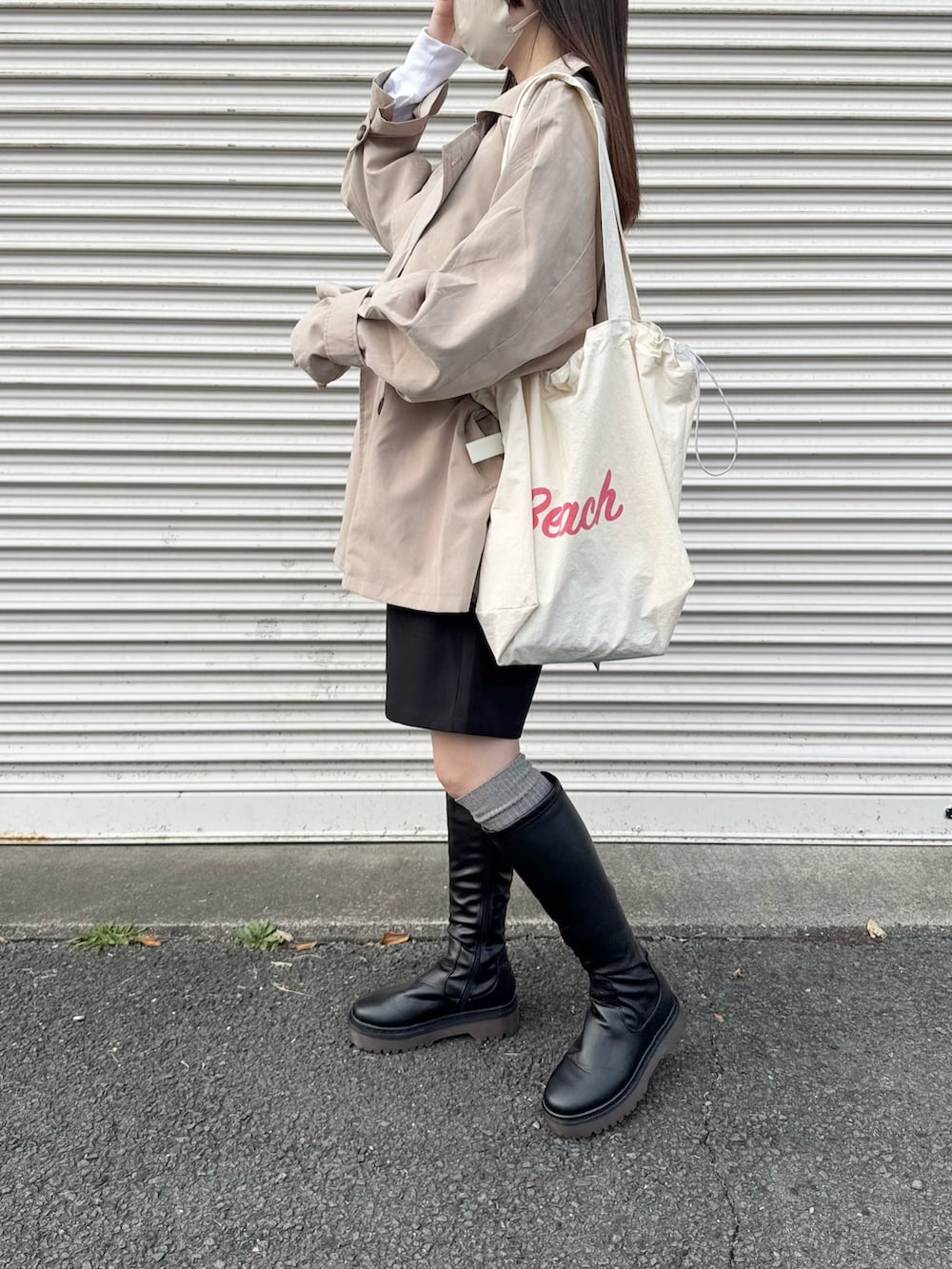 ベージュ系のトレンチコートを着用したレディースの春コーディネートの2枚目の写真