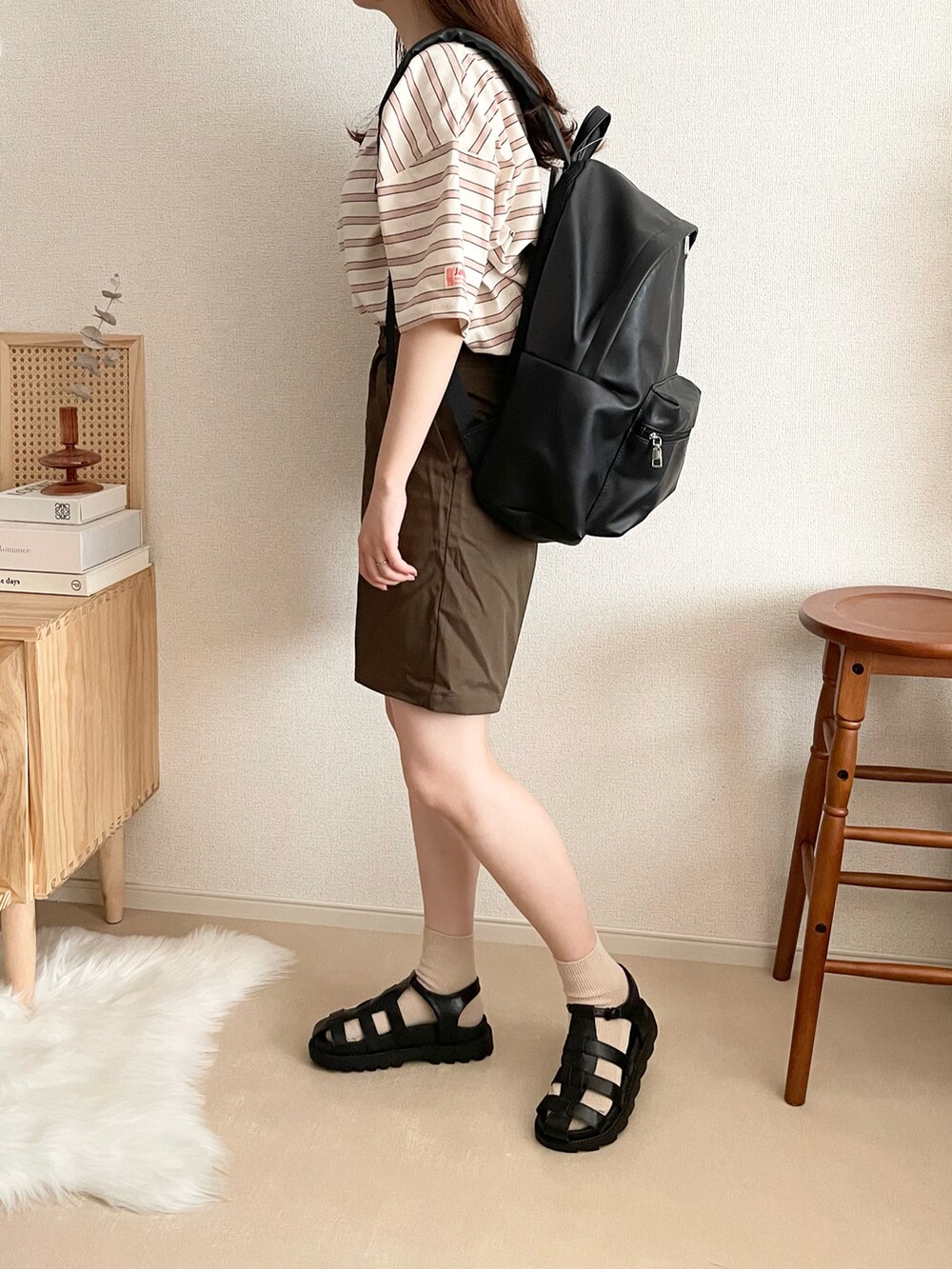 ブラック系のバックパック/リュック、ブラウン系のその他パンツ、ブラック系のサンダルを着用したレディースの夏コーディネートの2枚目の写真