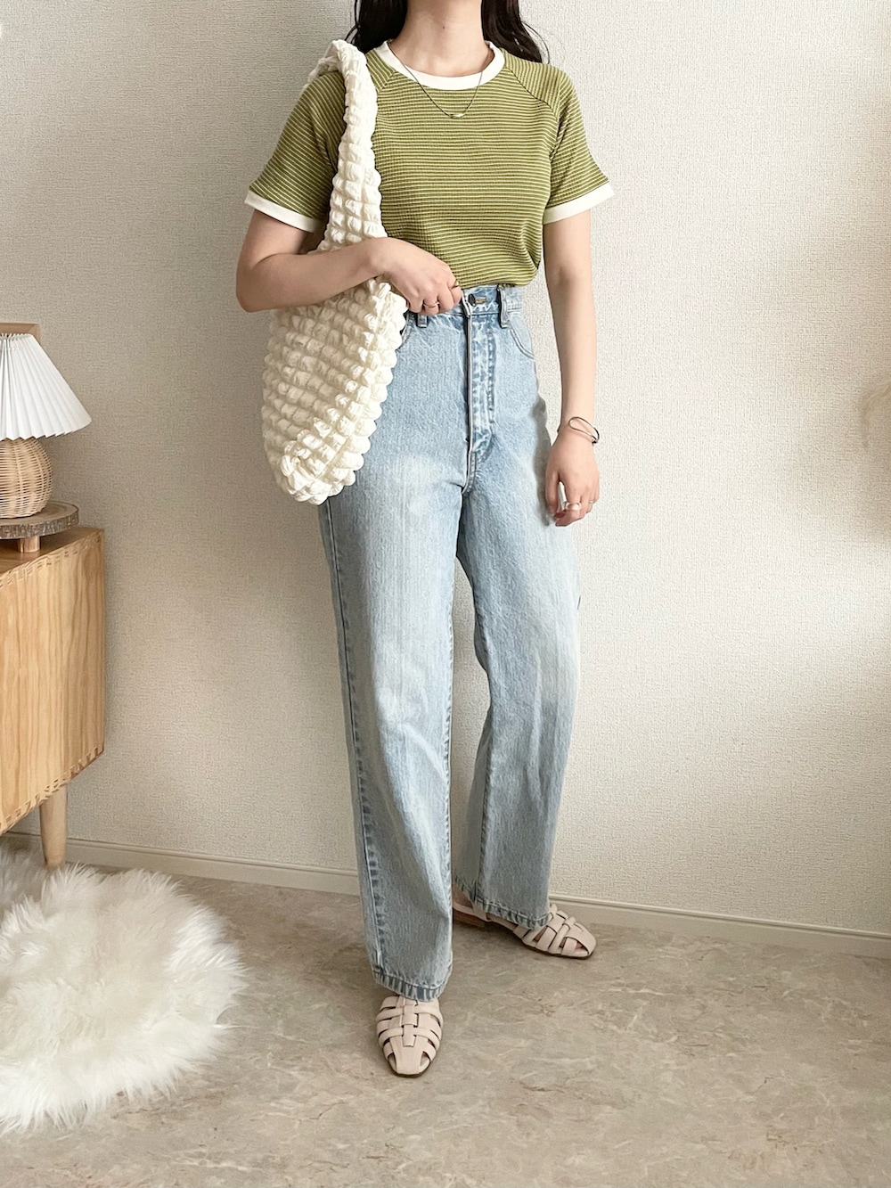 グリーン系のTシャツ/カットソー、ベージュ系のデニムスカート、ブラック系のショルダーバッグを着用したレディースの夏コーディネートの4枚目の写真