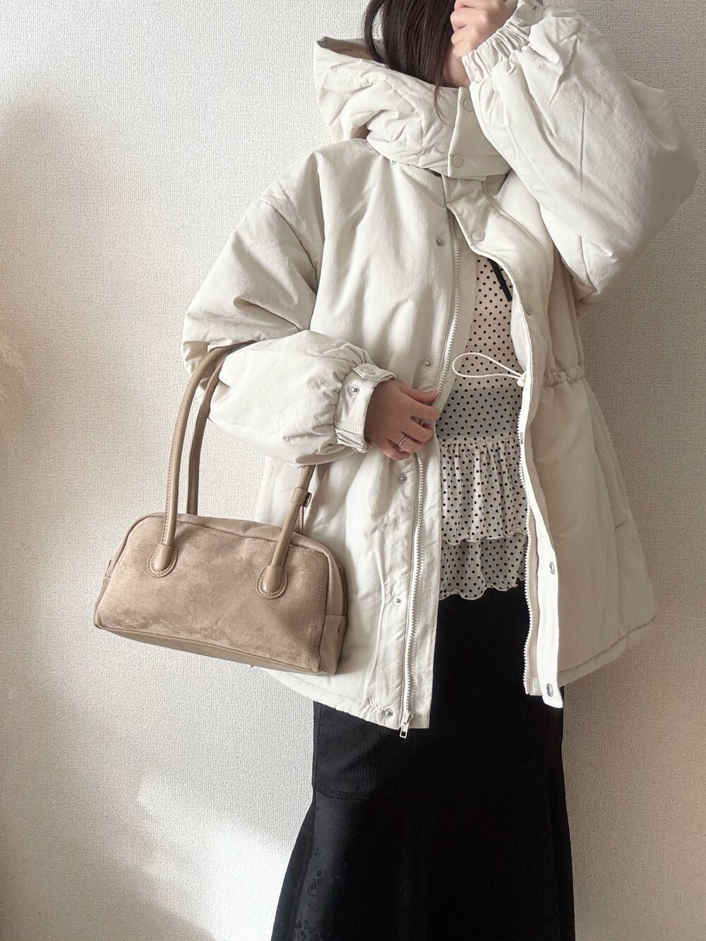 ホワイト系のダウンジャケット/コート、ホワイト系のTシャツ/カットソー、ホワイト系のスカートを着用したレディースの冬コーディネートの2枚目の写真