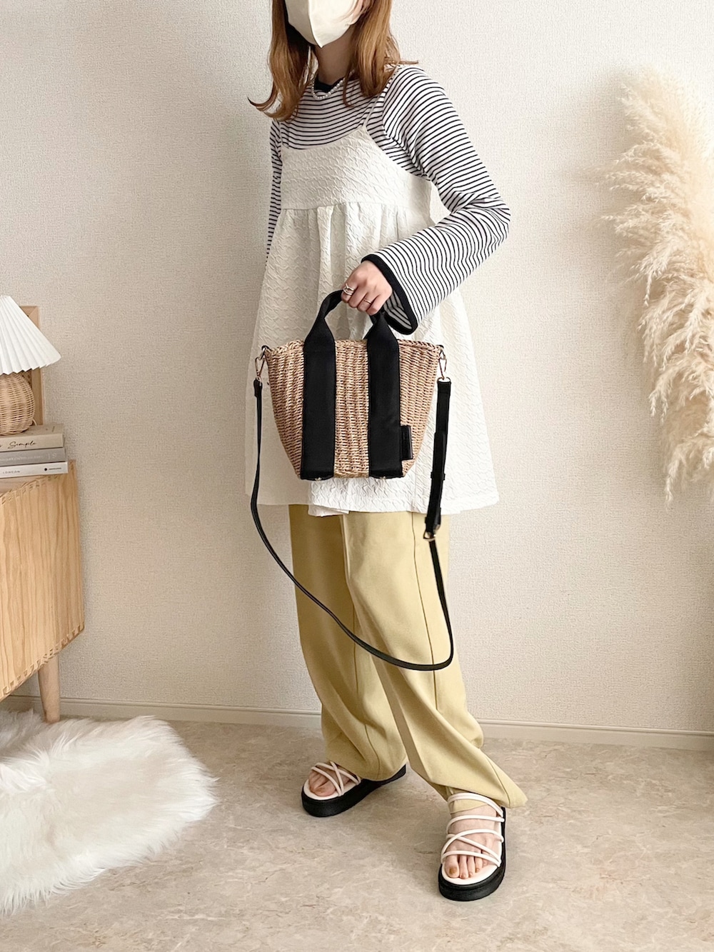 ホワイト系のワンピース、ブラック系のTシャツ/カットソー、ベージュ系のショルダーバッグを着用したレディースの春コーディネートの2枚目の写真