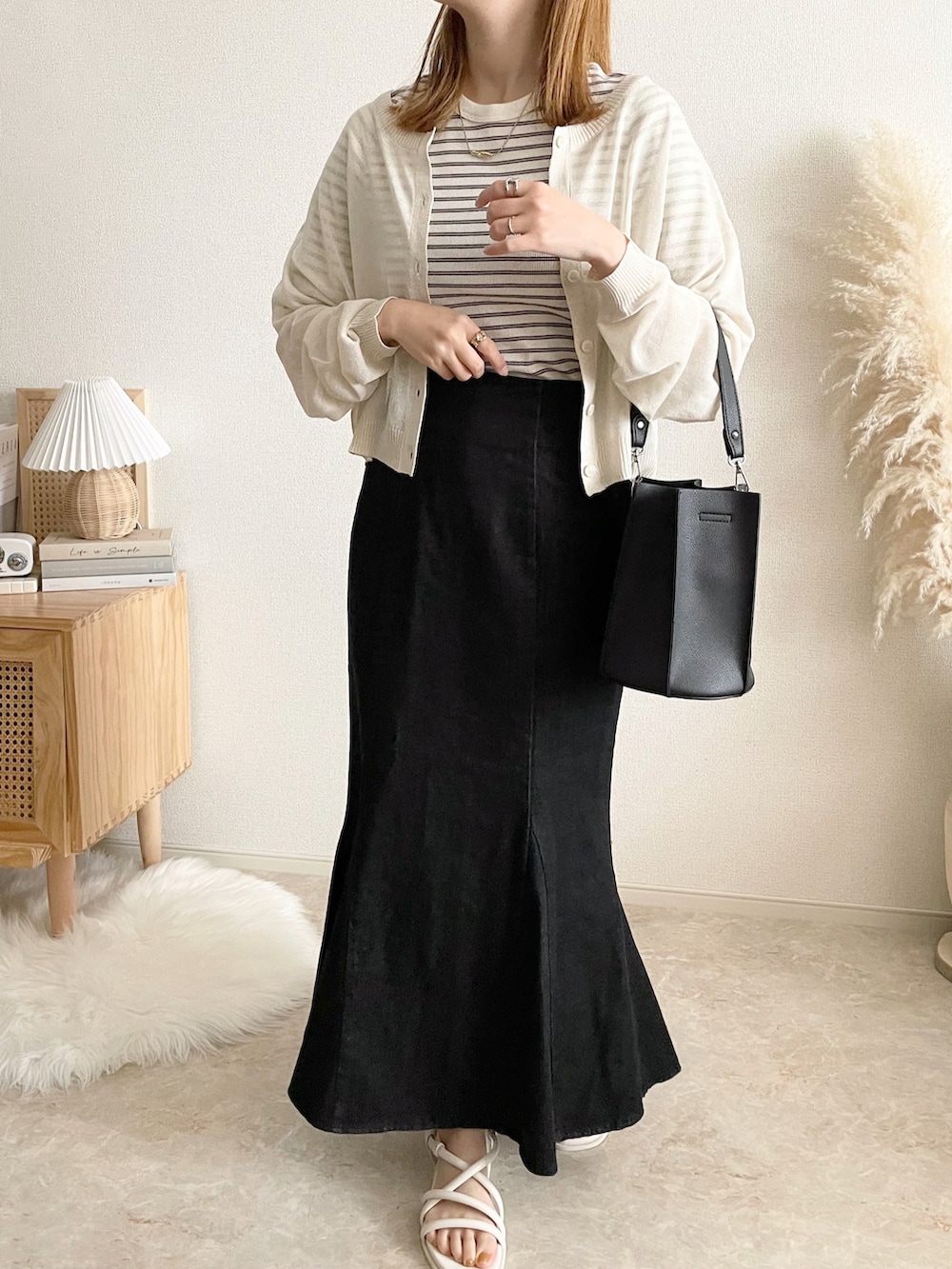 ホワイト系のカーディガン/ボレロ、ホワイト系のTシャツ/カットソー、ブラック系のデニムスカートを着用したレディースの春コーディネートの2枚目の写真