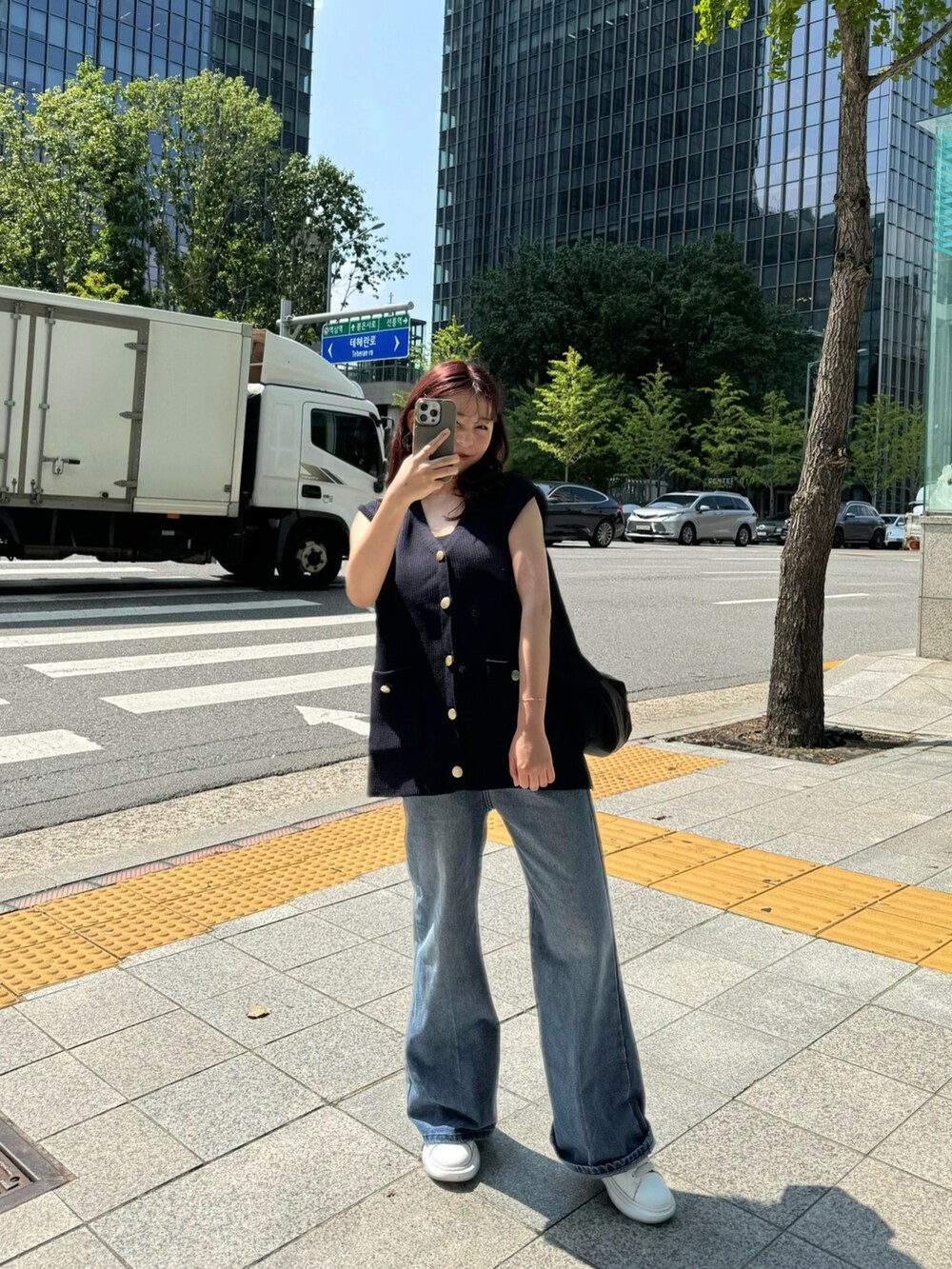 ブルー系のベスト、ブルー系のデニムパンツを着用したレディースの秋コーディネートの2枚目の写真