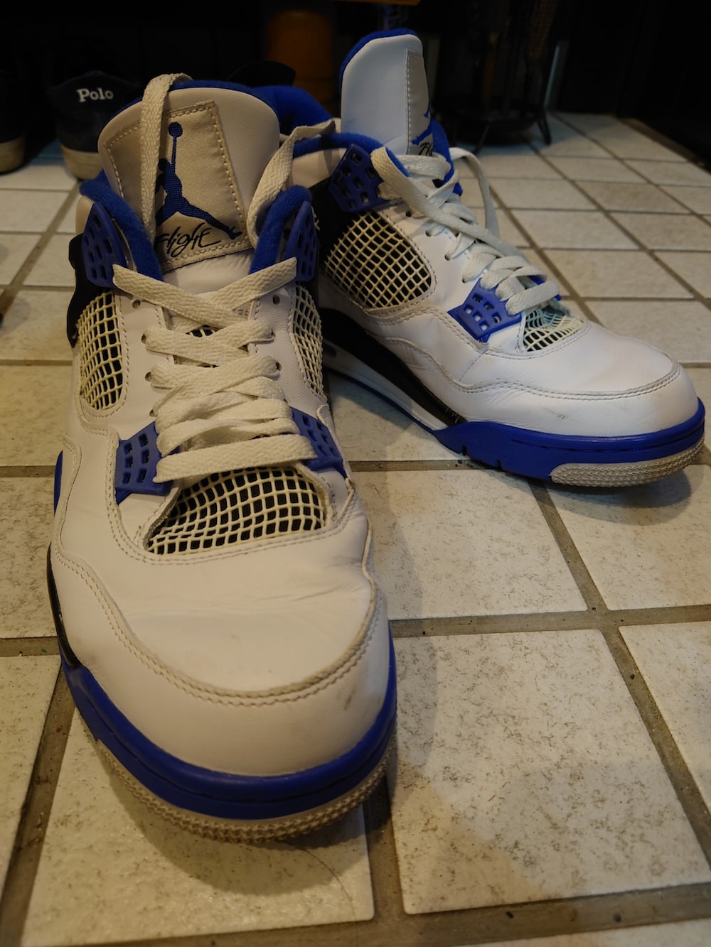 ブルー系のナイロンジャケット、ホワイト系のスニーカー、ブラック系のカーゴパンツを着用したメンズの春コーディネートの2枚目の写真