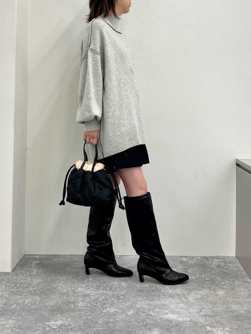 グレー系のニット/セーター、ブラック系のその他パンツ、ブラック系のブーツを着用したレディースの秋コーディネートの5枚目の写真