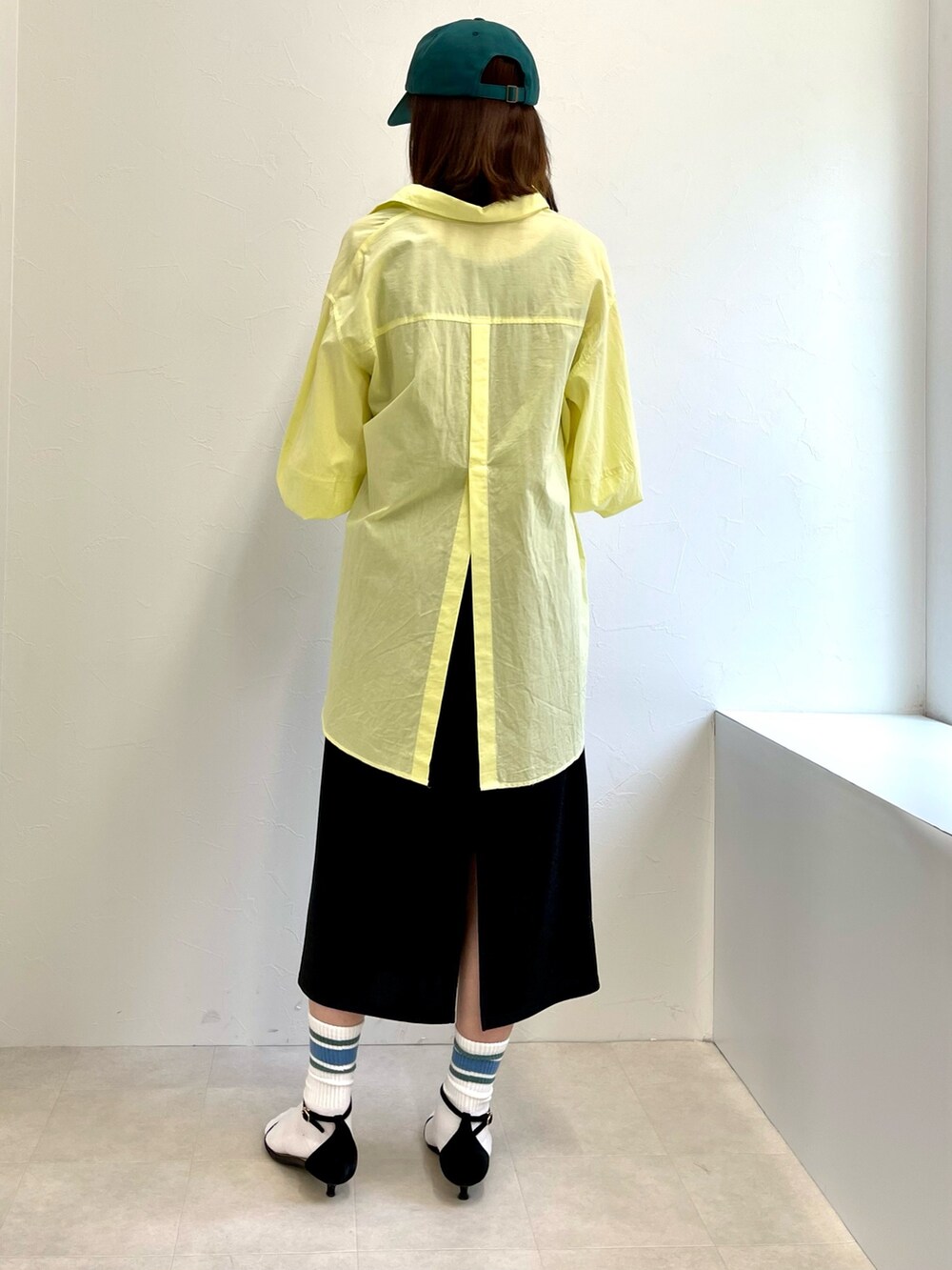 ブラック系のタンクトップ、ブラック系のスカート、イエロー系のシャツ/ブラウスを着用したレディースの春コーディネートの4枚目の写真