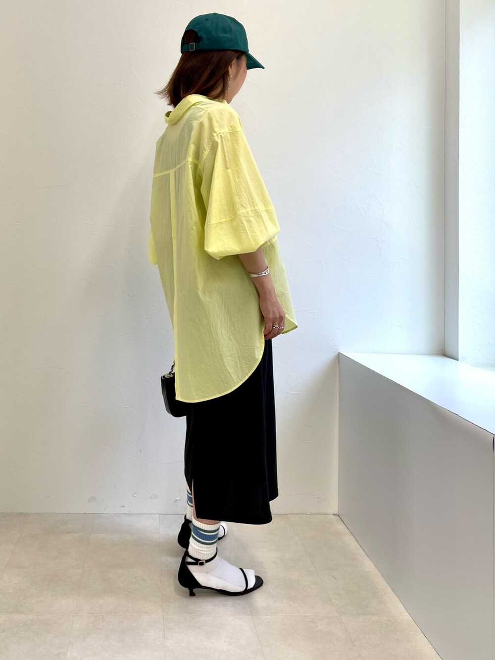 ブラック系のタンクトップ、ブラック系のスカート、イエロー系のシャツ/ブラウスを着用したレディースの春コーディネートの3枚目の写真