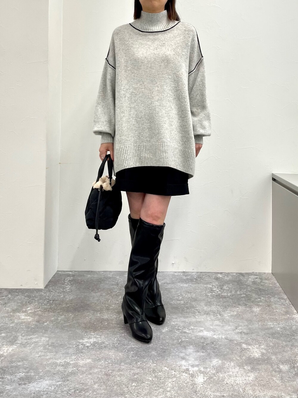 グレー系のニット/セーター、ブラック系のその他パンツ、ブラック系のブーツを着用したレディースの秋コーディネートの7枚目の写真