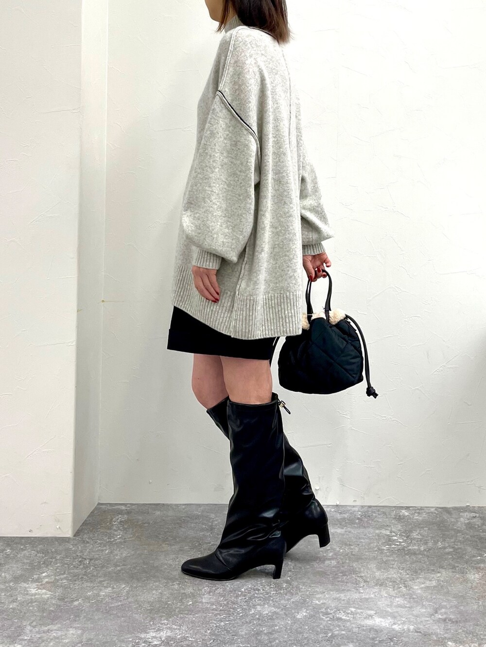 グレー系のニット/セーター、ブラック系のその他パンツ、ブラック系のブーツを着用したレディースの秋コーディネートの4枚目の写真