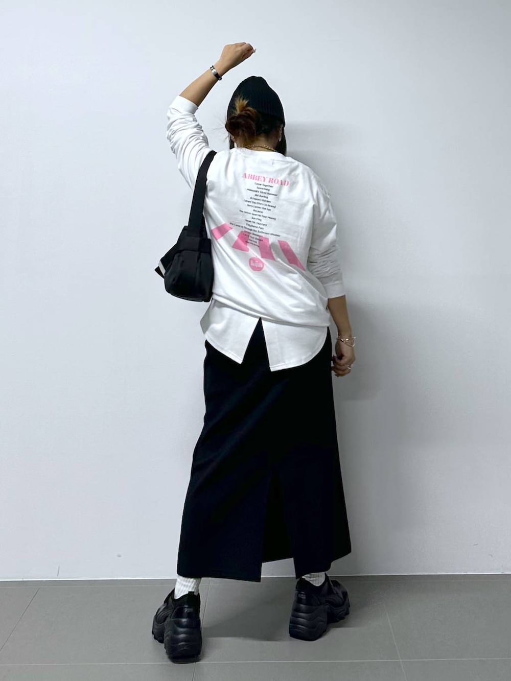 ブラック系のスニーカー、ホワイト系のTシャツ/カットソー、ブラック系のショルダーバッグを着用したレディースの夏コーディネートの5枚目の写真