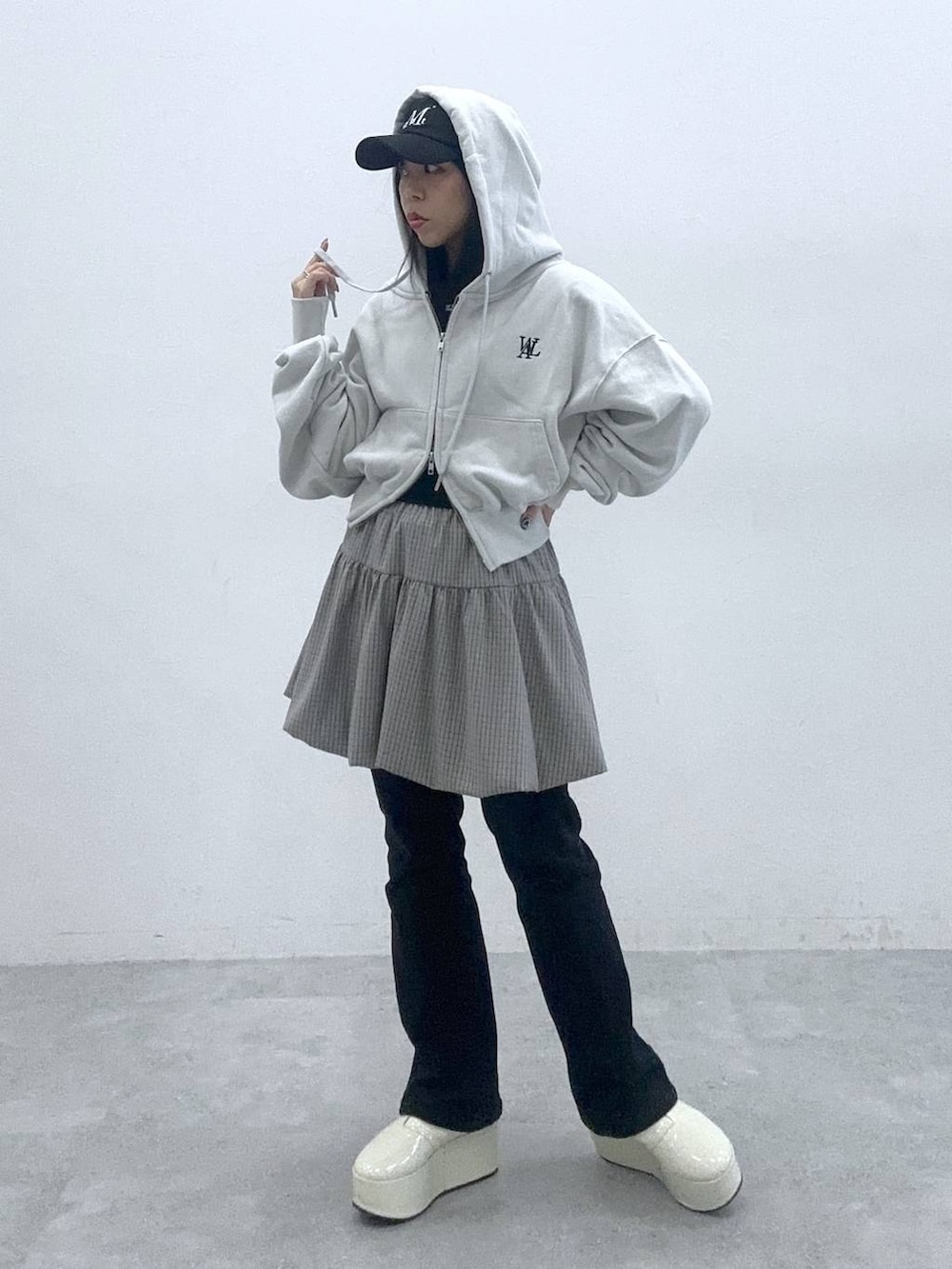 ブラック系のタンクトップ、グレー系のスカート、グレー系のパーカーを着用したレディースの春コーディネートの4枚目の写真