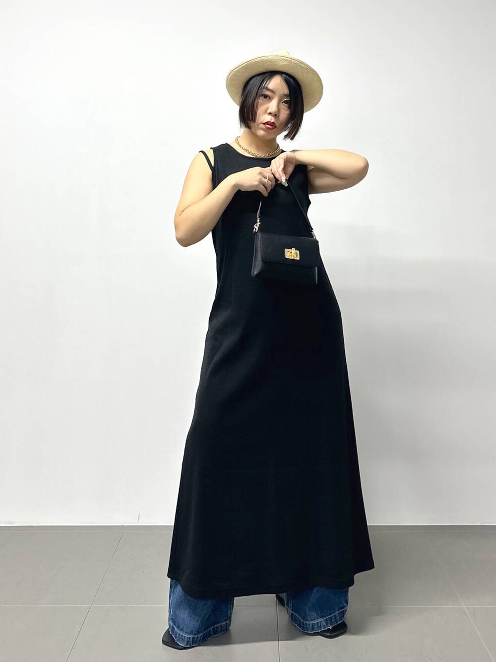 ブラック系のショルダーバッグ、ブルー系のデニムパンツ、その他のサンダルを着用したレディースの夏コーディネートの2枚目の写真