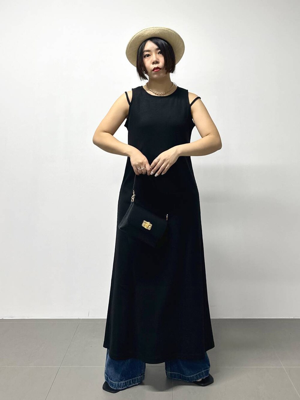 ブラック系のショルダーバッグ、ブルー系のデニムパンツ、その他のサンダルを着用したレディースの夏コーディネートの4枚目の写真