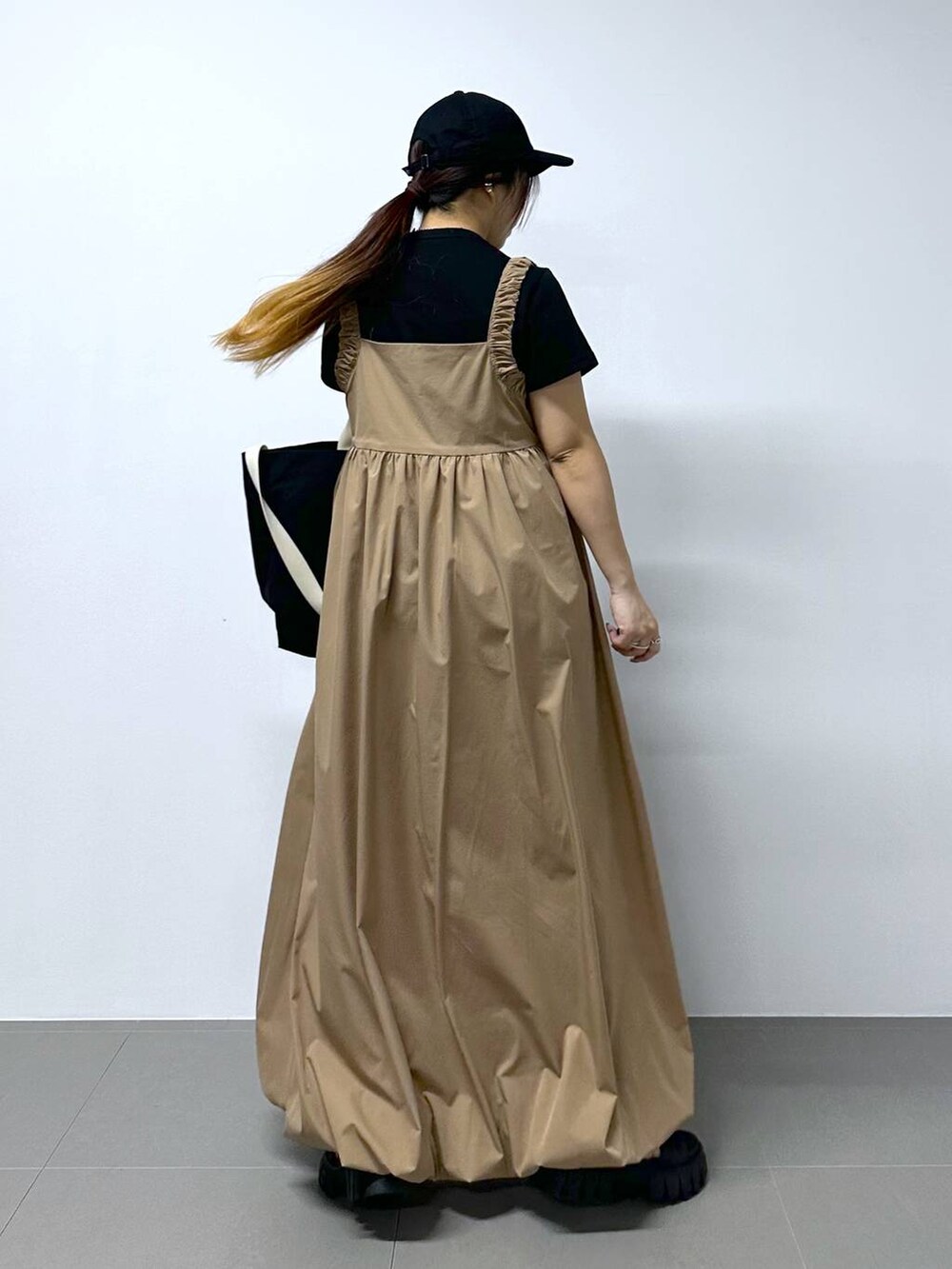 ベージュ系のワンピース、ブラック系のTシャツ/カットソーを着用したレディースの春コーディネートの5枚目の写真