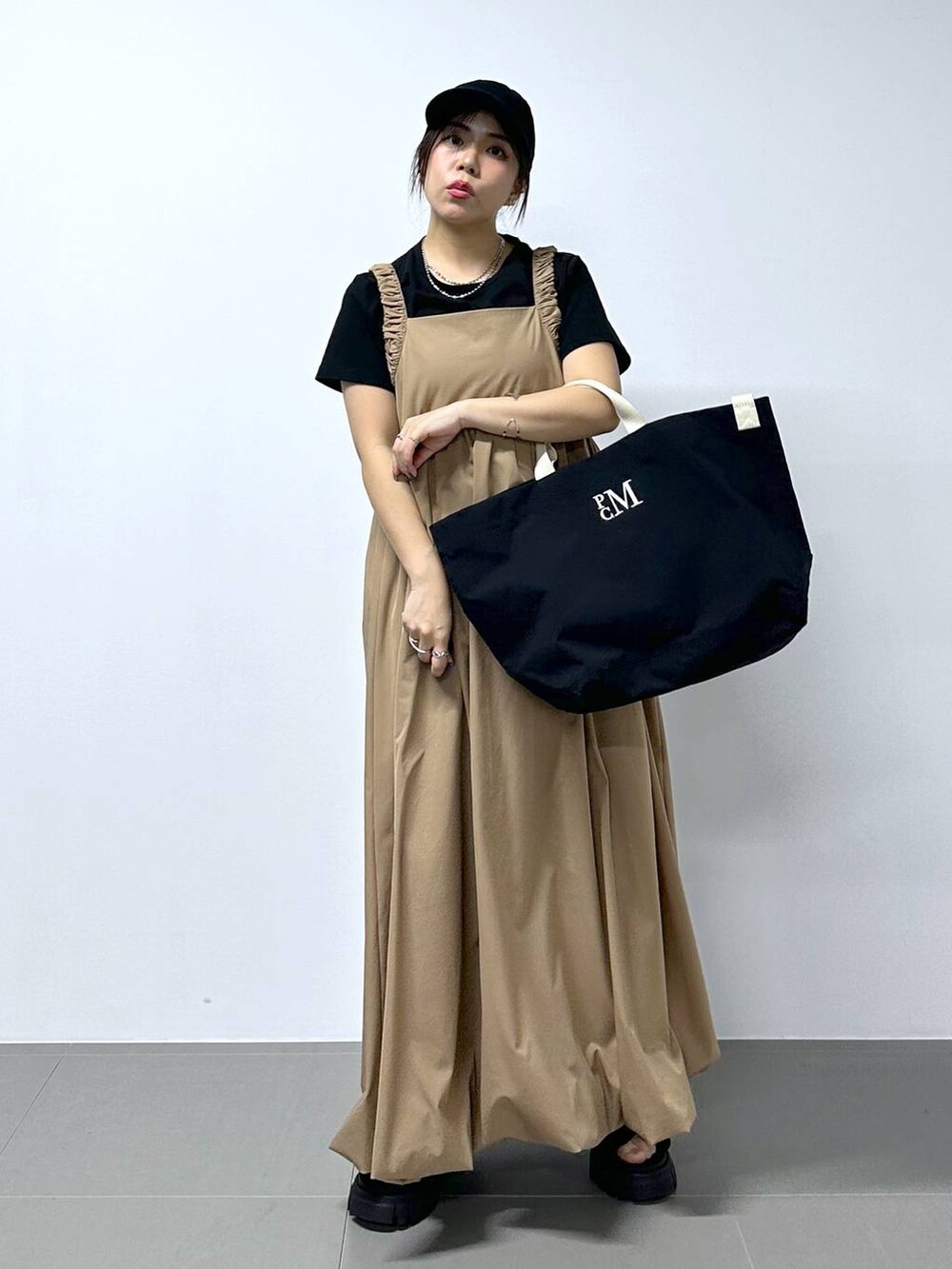 ベージュ系のワンピース、ブラック系のTシャツ/カットソーを着用したレディースの春コーディネートの4枚目の写真