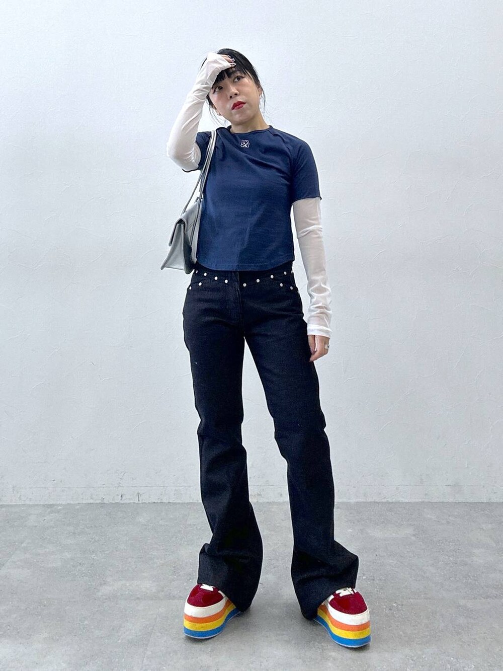 シルバー系のショルダーバッグ、ブルー系のデニムパンツ、ブルー系のTシャツ/カットソーを着用したレディースの春コーディネートの2枚目の写真