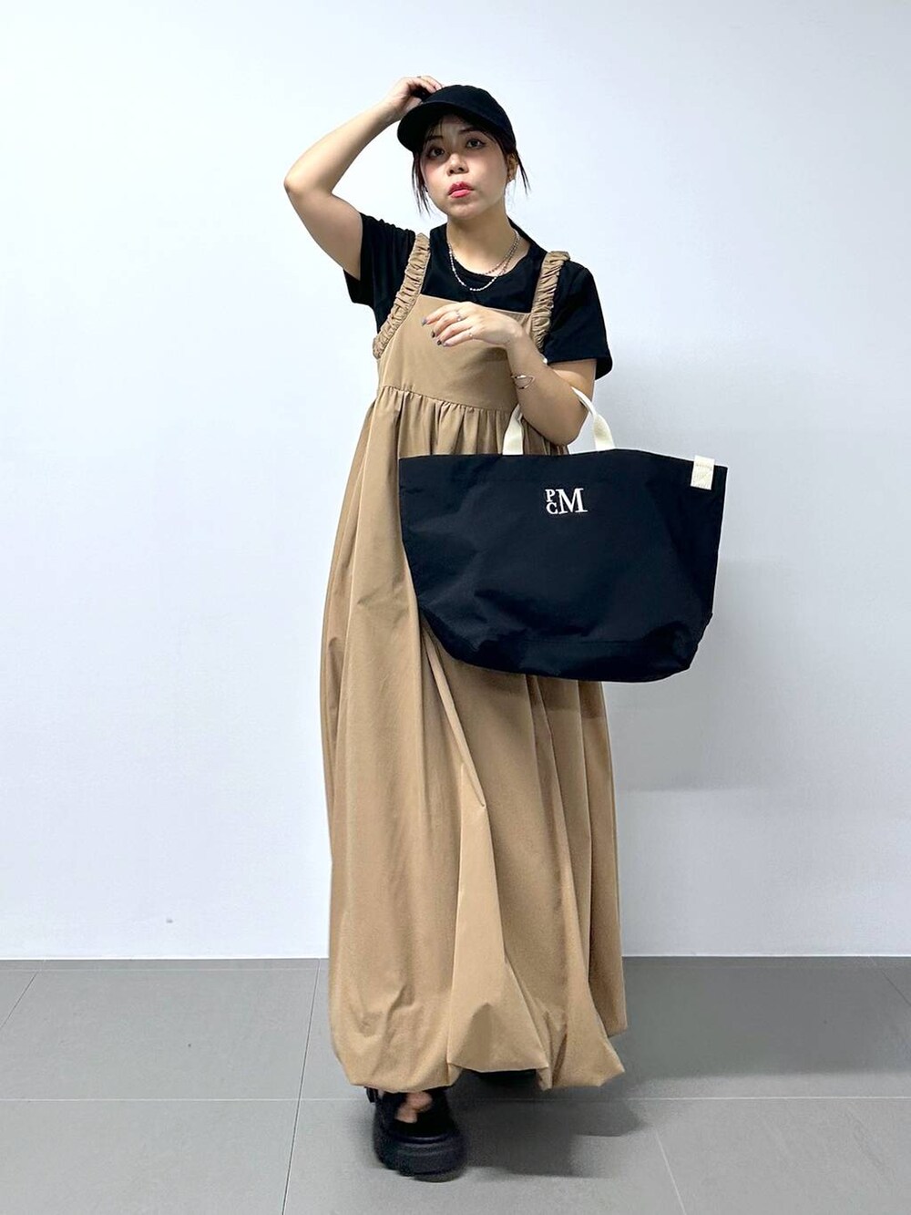 ベージュ系のワンピース、ブラック系のTシャツ/カットソーを着用したレディースの春コーディネートの3枚目の写真