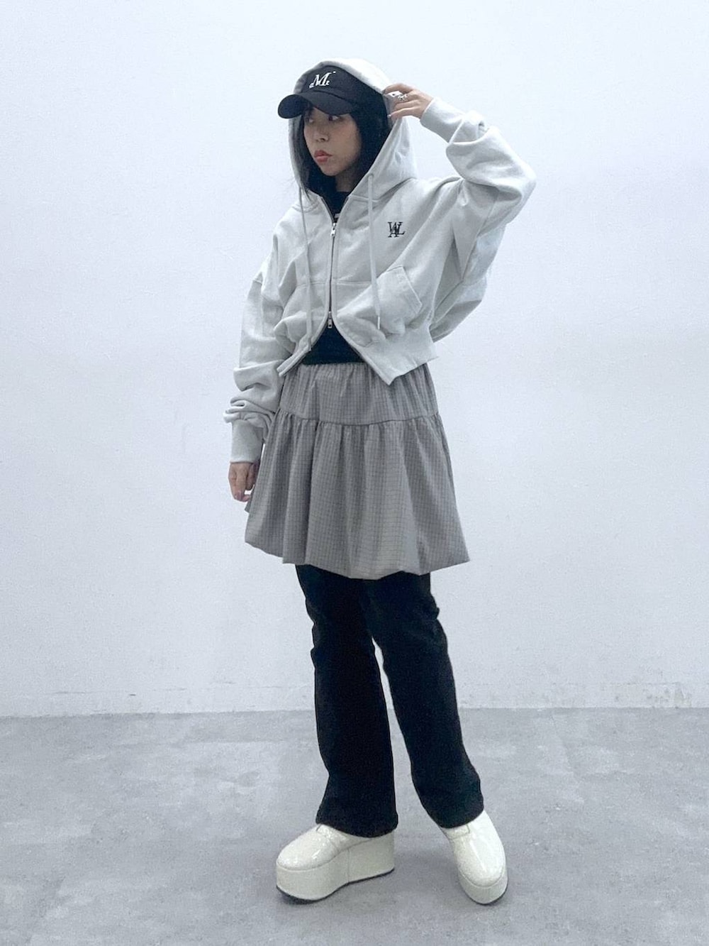 ブラック系のタンクトップ、グレー系のスカート、グレー系のパーカーを着用したレディースの春コーディネートの2枚目の写真