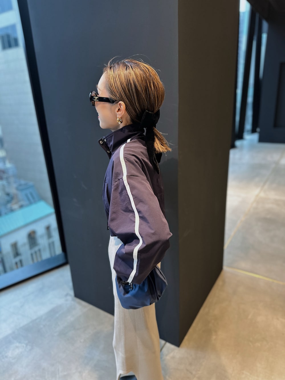 ブルー系のブルゾン、ブルー系のバッグ、ブラック系のブーツを着用したレディースの冬コーディネートの3枚目の写真